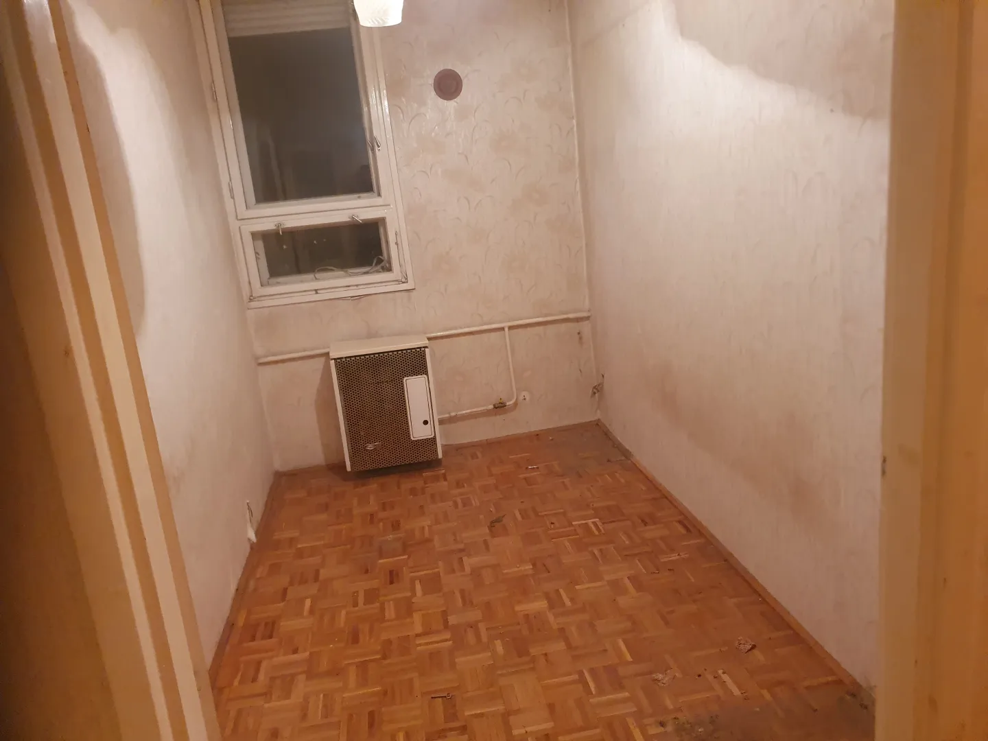 Kiürített szoba, látható parkettával és ablakkal